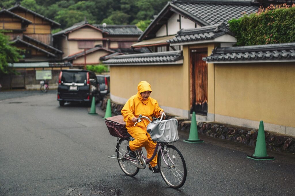 雨の中自転車を乗る女性