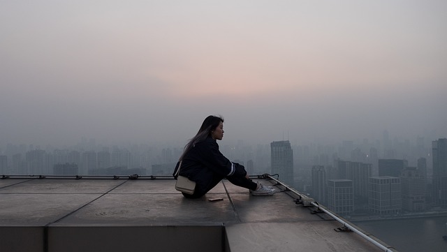 屋上で一人で座る女性